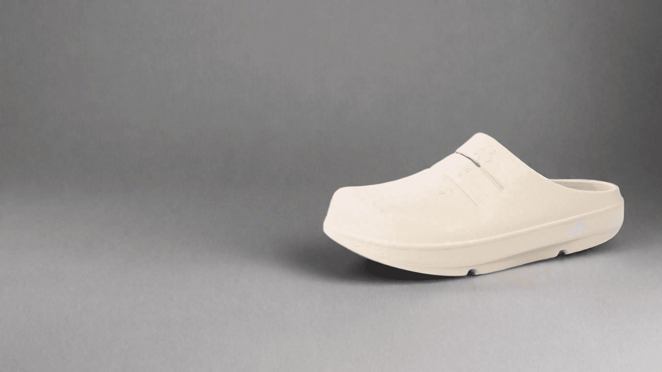 A single cream Fanture Halo clog on a plain cool-grey studio ground, side on and facing left, closed over the toes and open at the heel, with a moulded slit across the instep and the arch mark pressed into the side of the sole