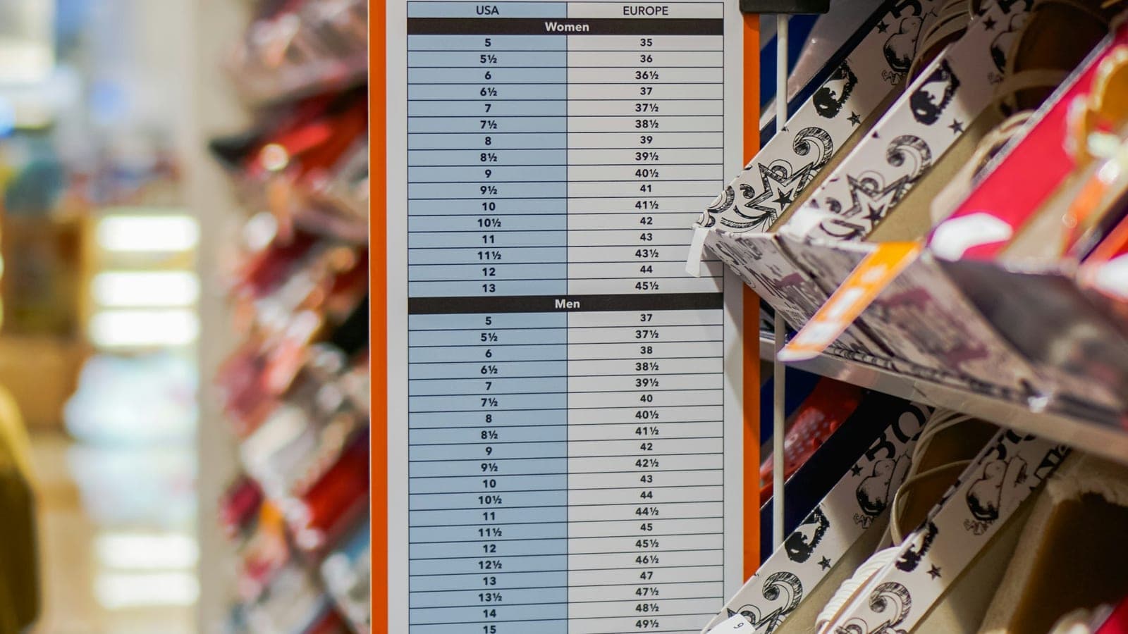 A printed shoe-size conversion chart hanging on the wall of a footwear shop, rows of European sizes set against their equivalents